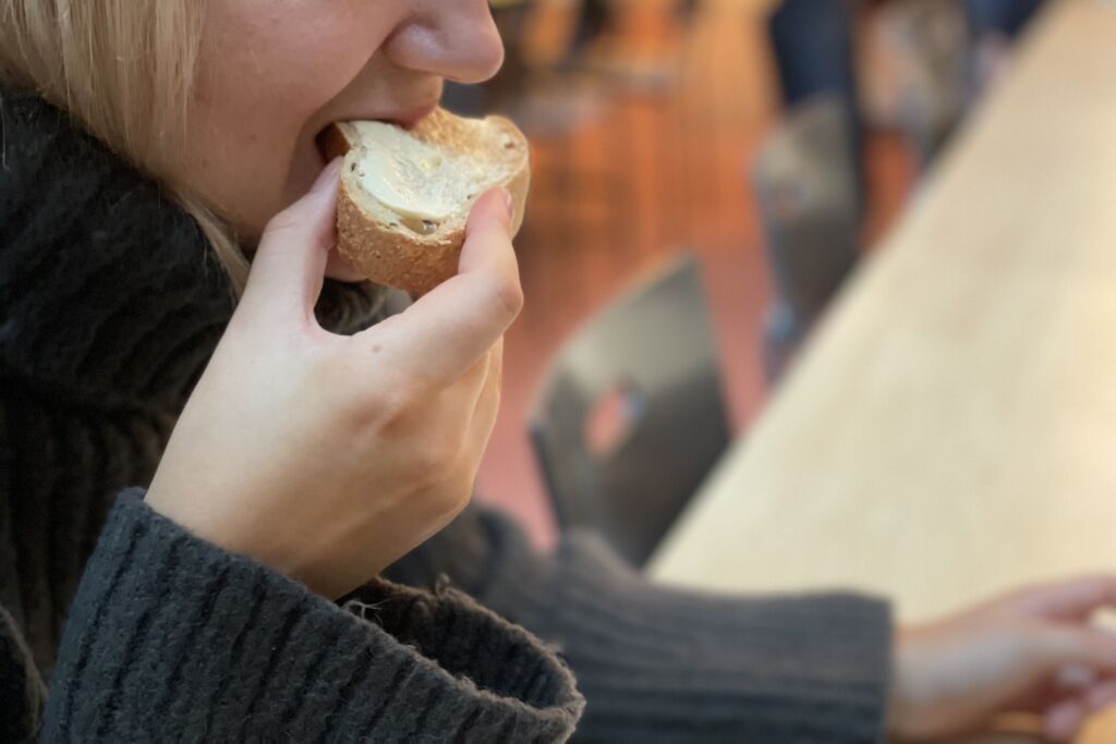 Nainen haukkaa leipää.