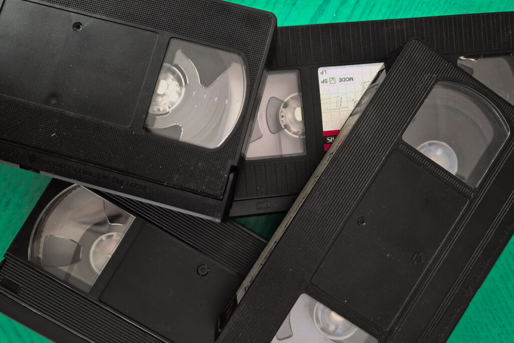 VHS-kasetit kasassa vihreällä taustalla.