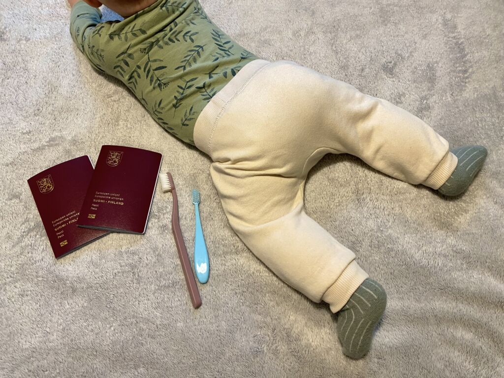 Kuvassa on vauva, kaksi passia ja kaksi hammasharjaa.