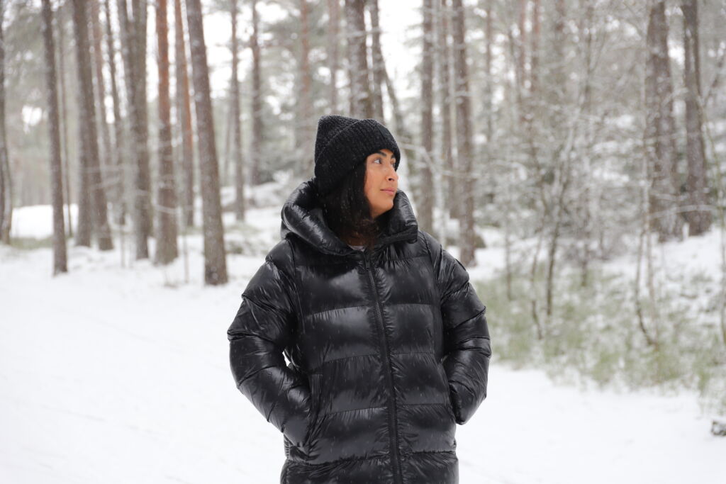 Melina seisomassa lumisessa metsässä.
