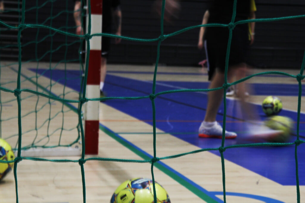 Kuvassa on futsal-verkko, jonka sisällä on jalkapalloja