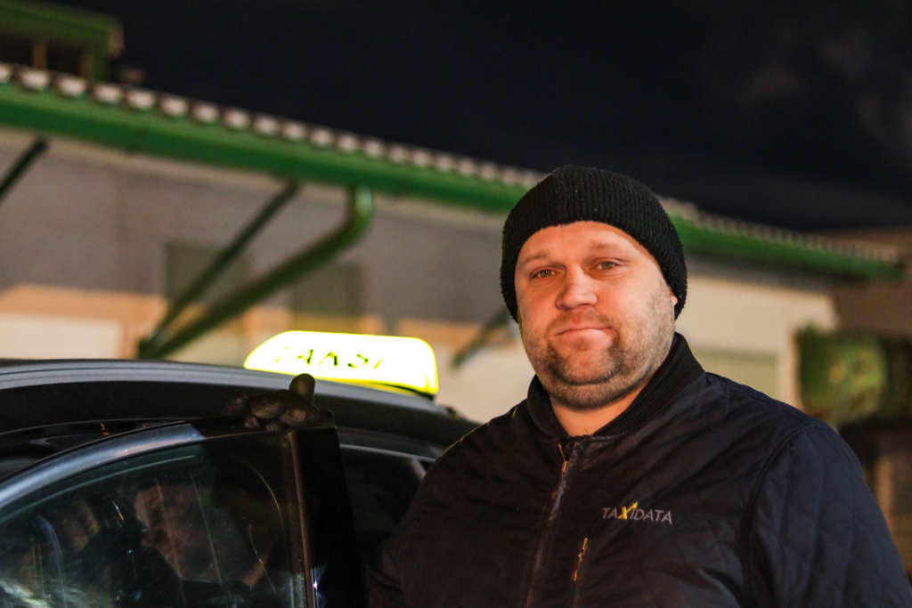 Ihminen taksin edustalla.