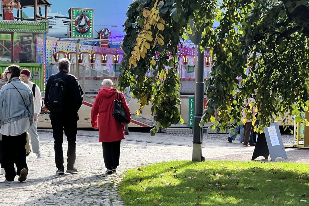 Kuvassa kadulla henkilöt, joilla musta ja punainen takki