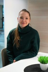 Jasmin Kuusisto istuu pöydän ääressä ja katsoo kameraan